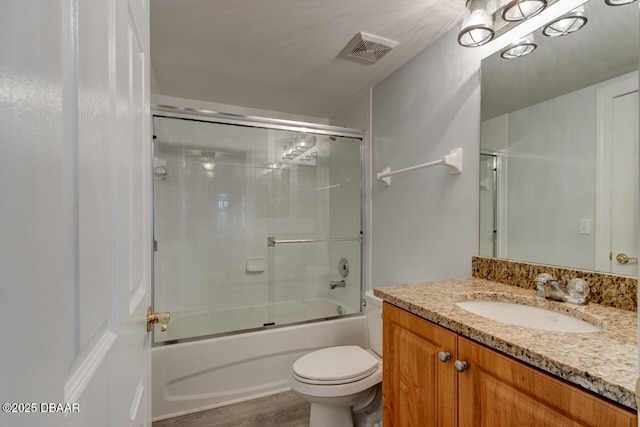 full bathroom with vanity, shower / bath combination with glass door, and toilet