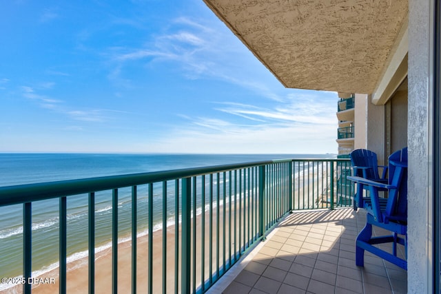 balcony with a water view and a view of the beach