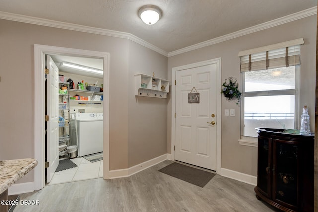 entryway featuring washer / clothes dryer, ornamental molding, and light hardwood / wood-style floors