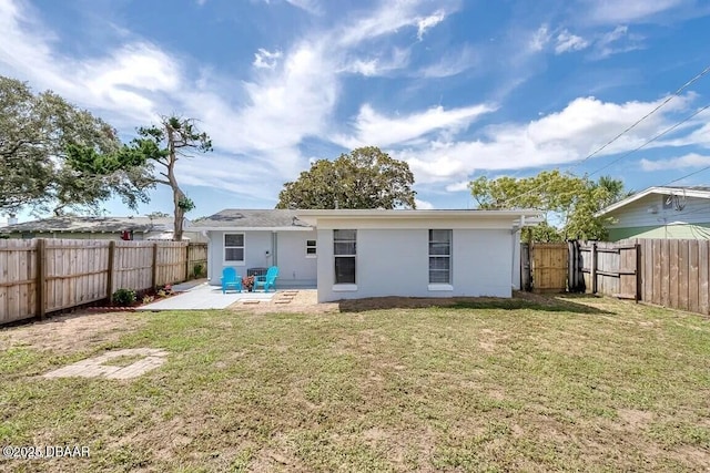 back of property featuring a yard and a patio