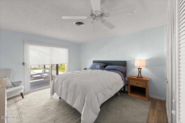 217 Royal Dunes Cir, Ormond Beach, FL 32176 - bedroom featuring access to exterior, wood finished floors, a textured ceiling, ceiling fan, and baseboards