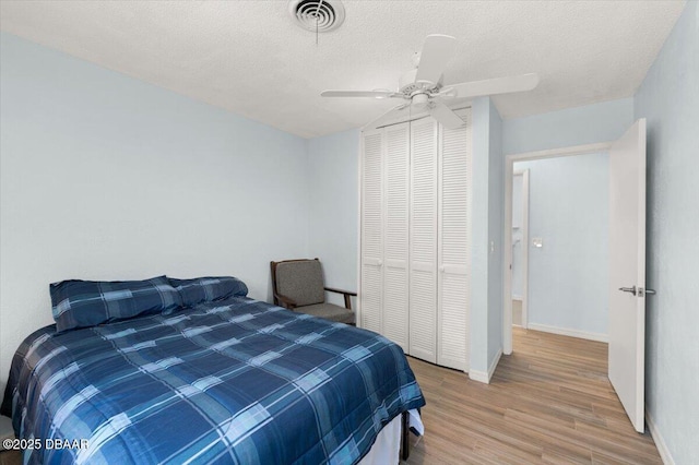 217 Royal Dunes Cir, Ormond Beach, FL 32176 - bedroom featuring wood finished floors, a closet, a textured ceiling, ceiling fan, and baseboards