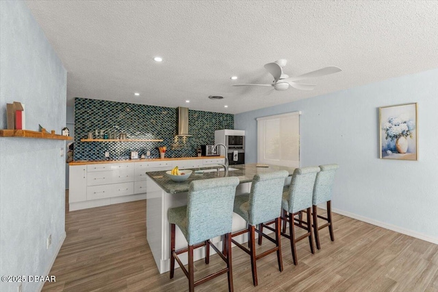 217 Royal Dunes Cir, Ormond Beach, FL 32176 - kitchen featuring a sink, white cabinetry, light wood-type flooring, open shelves, and a textured ceiling