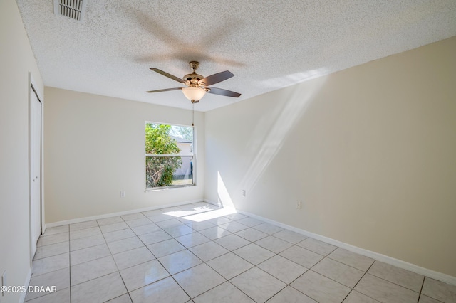 unfurnished room with light tile patterned floors, a textured ceiling, visible vents, baseboards, and a ceiling fan