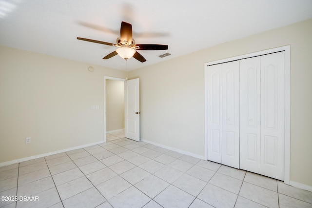 unfurnished bedroom featuring light tile patterned floors, a closet, ceiling fan, baseboards, and visible vents