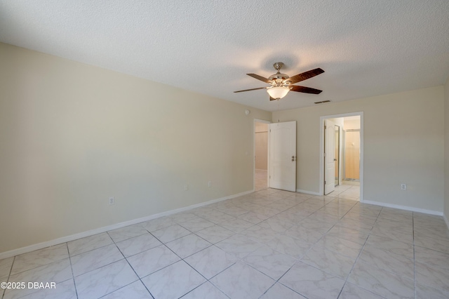 spare room with a ceiling fan, visible vents, a textured ceiling, and baseboards