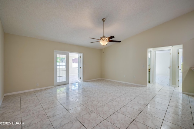 unfurnished room with baseboards, ceiling fan, a textured ceiling, and light tile patterned flooring