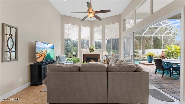 living room with a sunroom, a healthy amount of sunlight, and a towering ceiling