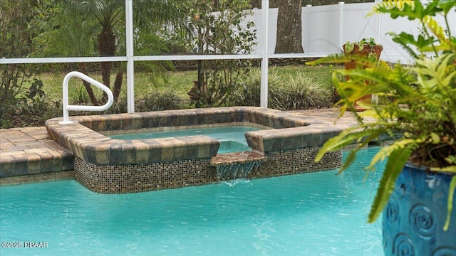 view of swimming pool with fence and an in ground hot tub