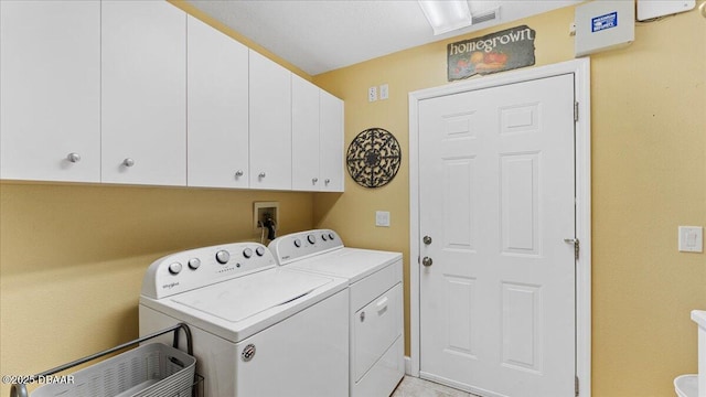 clothes washing area featuring washer and clothes dryer and cabinet space