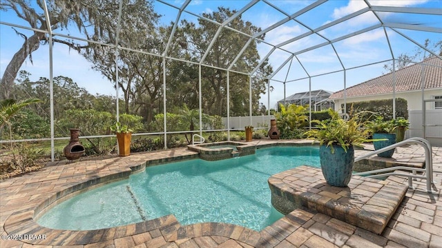 view of pool with a pool with connected hot tub, a lanai, a patio, and fence