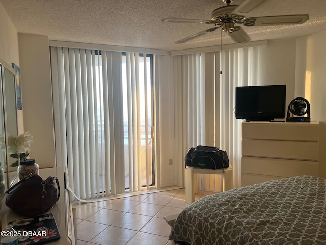 bedroom featuring light tile patterned floors, a ceiling fan, and a textured ceiling