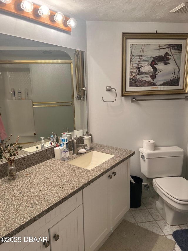 full bath with toilet, a textured ceiling, a shower with door, and vanity