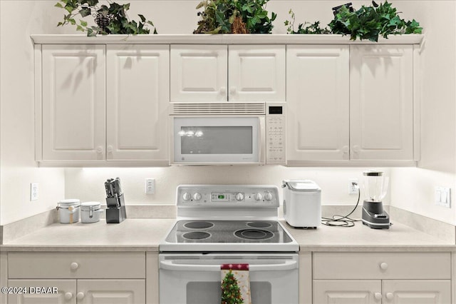 kitchen with white cabinetry and white appliances