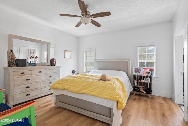 bedroom featuring a textured ceiling, light hardwood / wood-style flooring, and ceiling fan