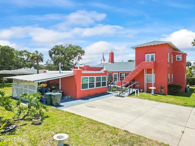 exterior space with a carport and a front lawn