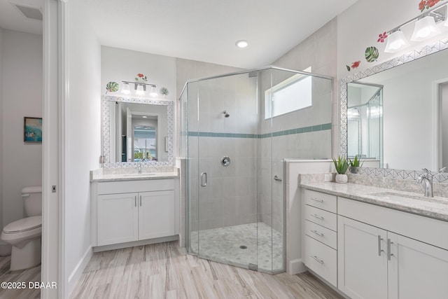 418 Good Life Way, Daytona Beach, FL 32124 - bathroom featuring vanity, hardwood / wood-style flooring, a shower with door, and toilet