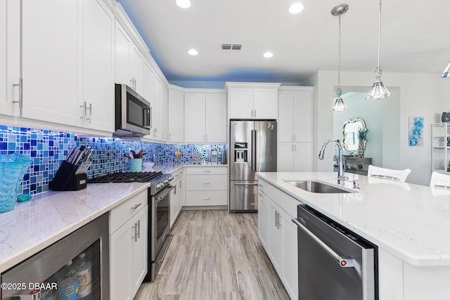 418 Good Life Way, Daytona Beach, FL 32124 - kitchen featuring white cabinetry, sink, wine cooler, high end appliances, and a center island with sink