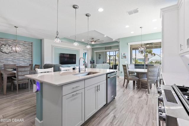 418 Good Life Way, Daytona Beach, FL 32124 - kitchen featuring sink, appliances with stainless steel finishes, white cabinetry, hanging light fixtures, and a center island with sink
