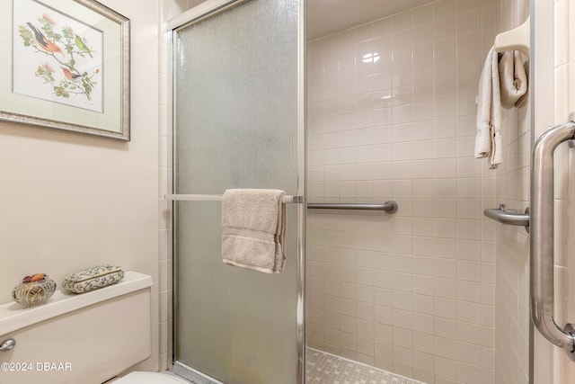 bathroom with toilet and a shower with door