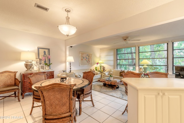 dining area featuring ceiling fan, a textured ceiling, and light tile patterned floors