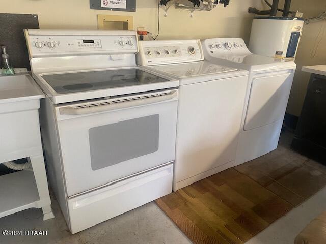 washroom with hardwood / wood-style floors, washer and dryer, and water heater