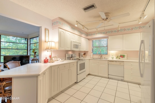 kitchen featuring a textured ceiling, white appliances, and sink