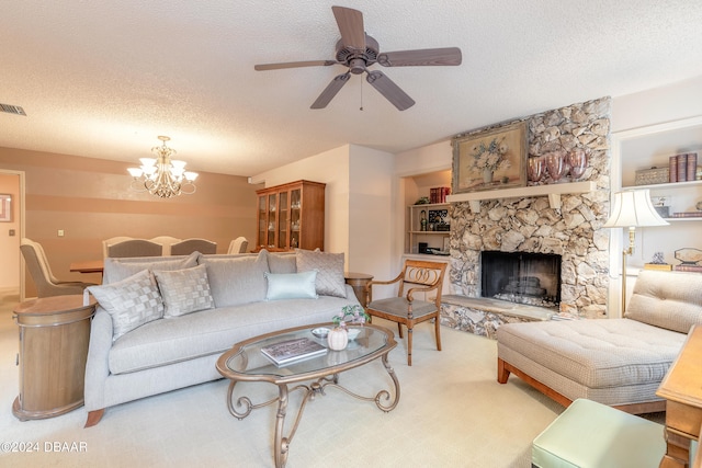 carpeted living room featuring a stone fireplace, ceiling fan with notable chandelier, and a textured ceiling