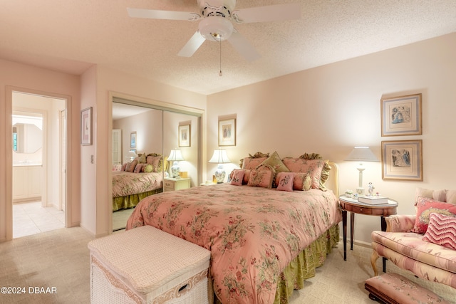 bedroom featuring a closet, a textured ceiling, light carpet, and ceiling fan