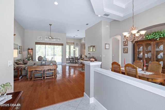 850 Westlake Dr, Ormond Beach, FL 32174 - interior space with visible vents, a towering ceiling, light tile patterned flooring, arched walkways, and ceiling fan with notable chandelier