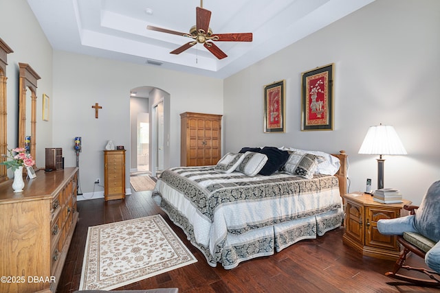 850 Westlake Dr, Ormond Beach, FL 32174 - bedroom with arched walkways, visible vents, a tray ceiling, and dark wood-type flooring