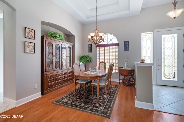 850 Westlake Dr, Ormond Beach, FL 32174 - dining room featuring wood-type flooring, a raised ceiling, baseboards, and a chandelier