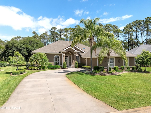 850 Westlake Dr, Ormond Beach, FL 32174 - view of front of home featuring curved driveway, a front lawn, and stucco siding