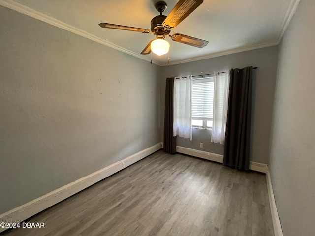 spare room featuring hardwood / wood-style floors, ceiling fan, and crown molding