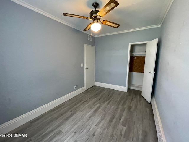 unfurnished bedroom featuring ornamental molding, a closet, hardwood / wood-style flooring, and ceiling fan