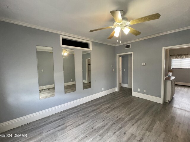 500 S Beach St Unit F-1, Daytona Beach, FL 32114 - unfurnished bedroom featuring wood finished floors, baseboards, ornamental molding, a ceiling fan, and a closet