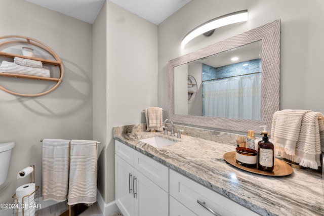 bathroom featuring walk in shower, vanity, and toilet