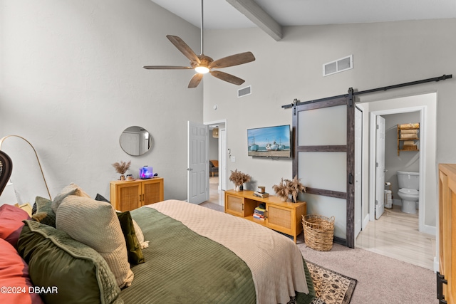 carpeted bedroom with beamed ceiling, ensuite bathroom, ceiling fan, high vaulted ceiling, and a barn door