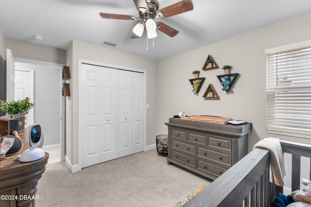 bedroom with a closet, light colored carpet, and ceiling fan