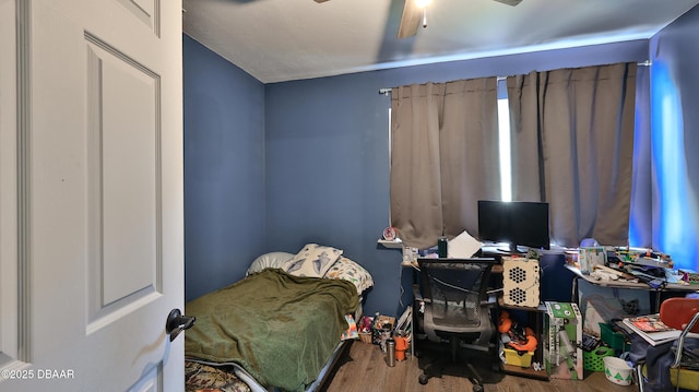 bedroom featuring wood finished floors, a desk, and ceiling fan