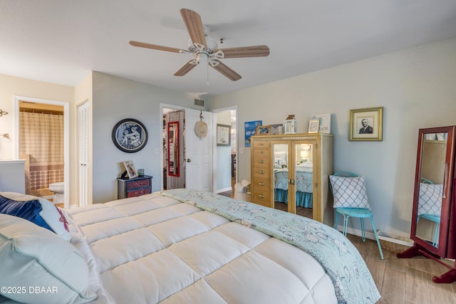 456 Bouchelle Dr Unit 104, New Smyrna Beach, FL 32169 - bedroom with visible vents, a ceiling fan, wood finished floors, connected bathroom, and baseboards