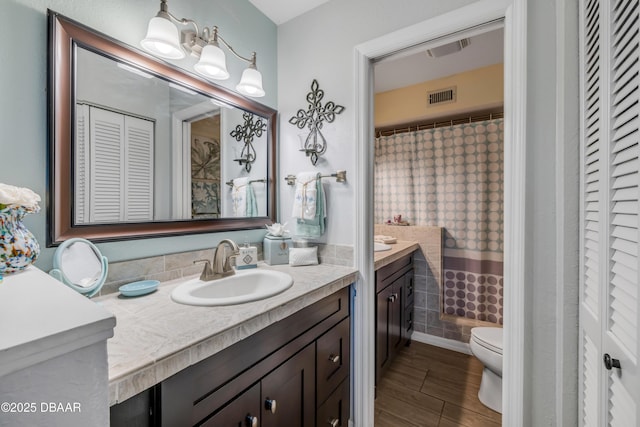 456 Bouchelle Dr Unit 104, New Smyrna Beach, FL 32169 - bathroom featuring a closet, toilet, visible vents, and vanity