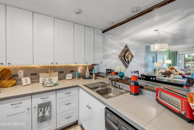 456 Bouchelle Dr Unit 104, New Smyrna Beach, FL 32169 - kitchen featuring a sink, decorative backsplash, and white cabinetry