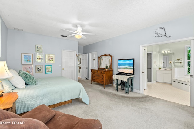 bedroom with visible vents, carpet flooring, ensuite bath, and ceiling fan