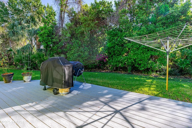 deck featuring a lawn and grilling area