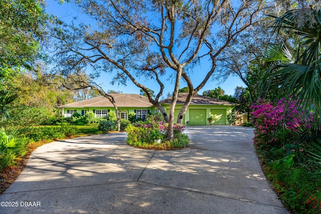 ranch-style home featuring concrete driveway and a garage