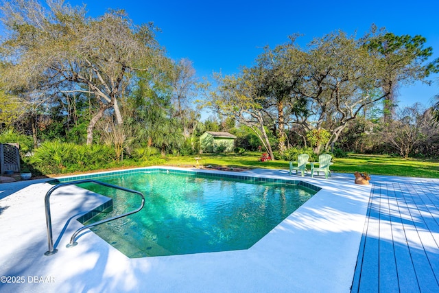 outdoor pool featuring a lawn