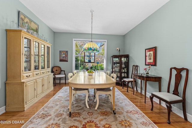 dining space featuring light wood-type flooring and baseboards