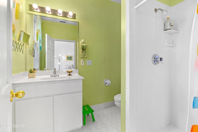 bathroom with tile patterned floors, toilet, vanity, and a tile shower