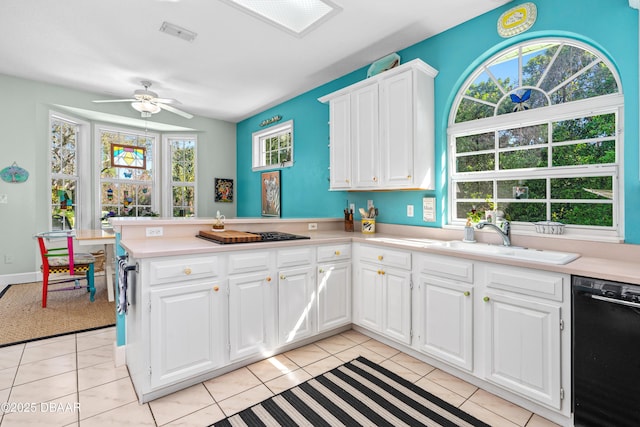 kitchen with a sink, black dishwasher, a peninsula, light countertops, and light tile patterned floors